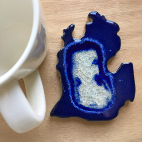 Bring your love of Michigan to your coffee table with this stunning handmade coaster. Resembling the crystalline, geological complexity of geode cross-sections, this stoneware and glass glazed trivet bring handcrafted beauty to functional home decor. The organic interaction of stoneware, glass, and colored glazes produces a unique, crackled surface with fascinating variations that make each coaster one-of-a-kind. Handmade by Kerry Brooks in Minneapolis, Minnesota. Due to the handmade nature of this item, each is unique and will vary. Size: approximately 5" x 3.5"
