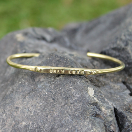 Brass adjustable bracelet features "only love" message Brass adjustable bracelet features "only love" message
