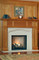 Our Orland wood mantel in Cherry, combined with our limestone Tudor surround and a limestone facing set