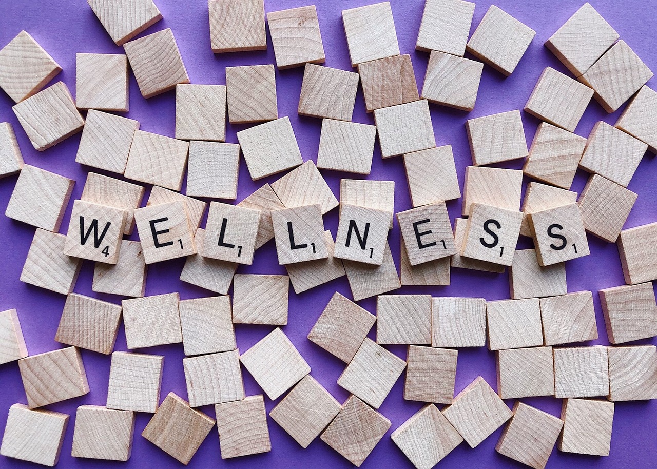 The word wellness spelled with scrabble tiles.