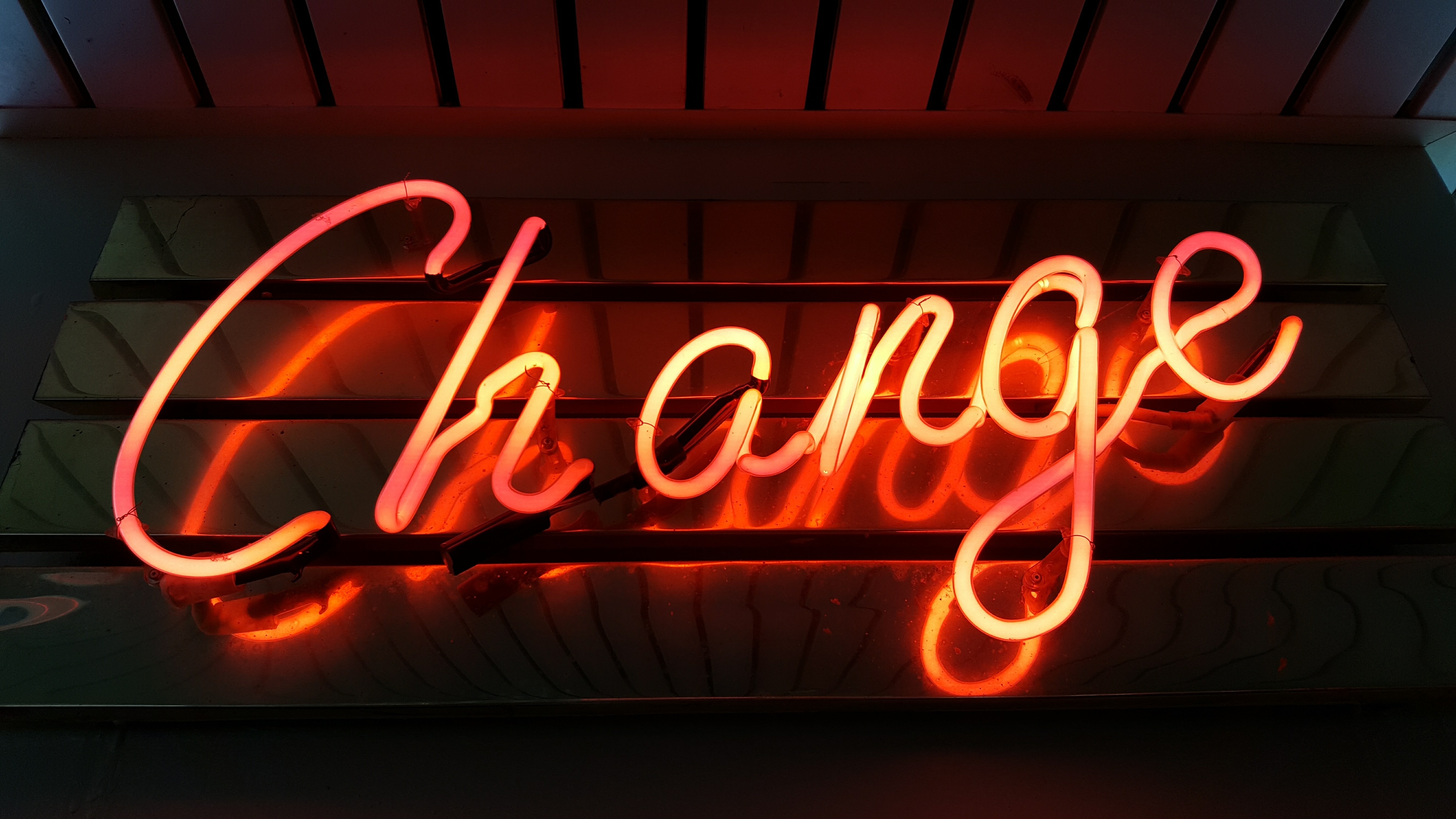 A neon sign with the word change brightly lit up.