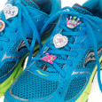 Shoelace charms on a pair of running shoes.