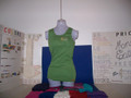 The tank top here is shown in leaf green. They are cotton and usually come 1x1 baby  ribbed for a quality look and feel. Most are 3.5oz. of cool comfortable bliss for her. I kept 2 locations even though it costs more so all the shirts match the pants/shorts. Locally, some sale item shirts may come in 1 location for cost, but online is always 2 for highest expected quality with no unwanted surprises.
