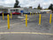 Removable Locking Bollards with Yellow Bollard Covers lining a parking lot 