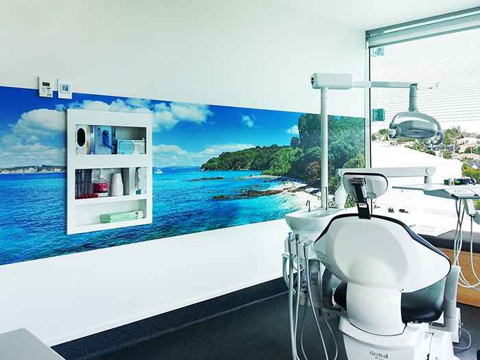 New Zealand beach scene printed vinyl wall mural featuring blue water, beach and sand.