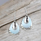 MEDIUM SIZED EARRINGS
STERLING EAR WIRE
SEA BLUE IN COLOR WITH HAMMERED SILVER