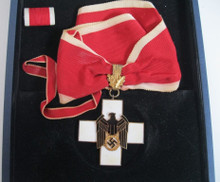 WW2 German Social Welfare Cross (Red Cross) First Class - in bronze gilt, that measures 52mm (width) x 52 (height), with full length of period neck ribbon, in slightly worn condition, remains near mint condition. Included is a ribbon bar for the German Social Welfare Cross: Second Class. The decoration came in a mismatched case for the Knights Cross of the War Service Cross with Swords which may be of 1957 issue vintage.