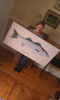Karen holding the original painting of her 2013 striped bass. You can purchase a limited edition giclee at the same size as the original.