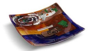 6 inch square blue glass platter featuring red and brown fused glass, touches of green and other colors and a white spiral