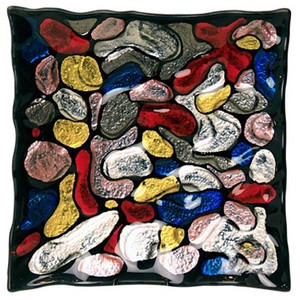 A 10" square fused glass plate featuring multiple colors of rock and obtuse shapes on a mostly black background