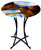 Hand painting is featured on this contemporary fused glass cafe table in hues of red, brown, black, white and blue.  Gold highlights added for detail
