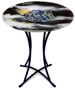A fused glass cafe table featuring black and white, with a multi-color marble look in its center
