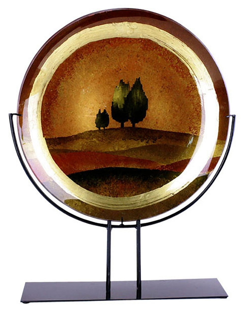 A large round fused glass platter featuring rolling hills in brown, and trees on the horizon.  Gold and brown metallic hand painting finishing touches