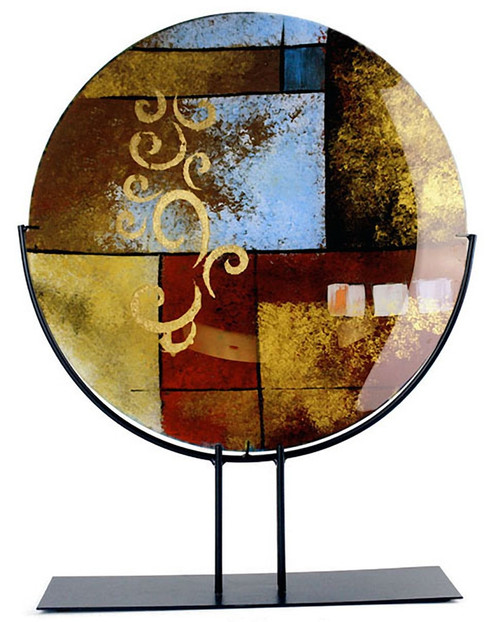 A large fused glass platter with abstract geometric shapes in gold, yellow, red and black with some hand painted gold finishing details