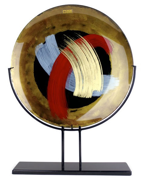 20 inch round fused glass platter, standing 25" tall, featuring gold and black, with hand painted blue, red and gold, broad brush strokes