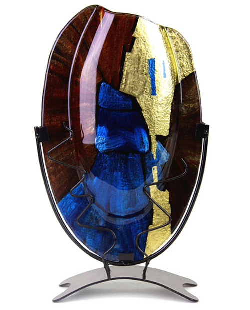 A 15 inch oval fused glass vase, from our Speedy series, featuring blue, brown and black, with metallic gold hand-painted details. Stand included