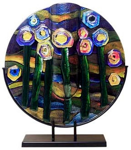 This 18-inch round fused glass platter features blue, violet, green, black and yellow with hints of pink.  Abstract flowers, reminiscent of a starry night.   Stand included