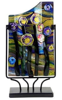 This 15-inch rectangular fused glass platter features primarily green and yellow, with touches of blue, violet and black with hints of pink.  Abstract flowers, reminiscent of a starry night.   Stand included