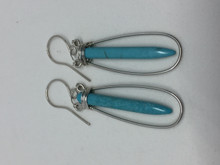 Fun and Lightweight. These sterling silver earrings add a pop of color to your ears. Handcrafted from sterling and fine silver wire and turquoise stones.  They hand approximately 2-1/2 inches below the ear.  Turquoise is the stone of abundance and the birthstone for December.