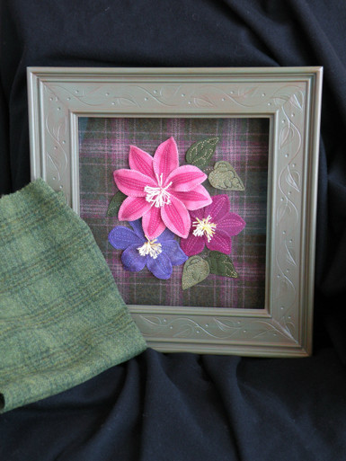 Current kit features the wool in the foreground as the background fabric.  Sorry, the pink plaid has long been sold out!  All the hand dyed wools for the flowers are the original colors/wools!
