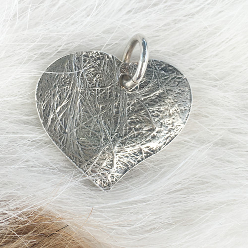 Silver charm featuring fur texture