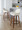 Daniella 26" Contemporary Fixed-Height Counter Stool with Swivel in Walnut Wood and Cream Fabric with Round Black Metal Footrest- Set of 2 — lifestyle photo 1