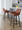 Daniella 26" Contemporary Fixed-Height Counter Stool with Swivel in Walnut Glazed Wood and Camel Faux Leather with Round Black Metal Footrest- Set of 2 — lifestyle photo 1