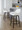 Daniella 26" Contemporary Fixed-Height Counter Stool with Swivel in Walnut Glazed Wood and White Faux Leather with Round Black Metal Footrest- Set of 2 — lifestyle photo 2