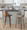 Gianna 26" Mid-Century Modern Fixed-Height Counter Stool with Swivel in Walnut Wood and Light Grey Faux Leather with Round Chrome Metal Footrest- Set of 2 — lifestyle photo 1
