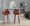 Dahlia 30" Contemporary Fixed-Height Barstool in Walnut Wood and Camel Faux Leather with Round Chrome Footrest- Set of 2 — lifestyle photo 1