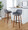 Daniella 30" Contemporary Fixed-Height Barstool with Swivel in Walnut Wood and Grey Faux Leather with Round Black Metal Footrest- Set of 2 — lifestyle photo 1