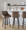 Hannah 30" Transitional Fixed-Height Barstool with Swivel in Walnut Glazed Wood and Brown Faux Leather with Round Black Metal Footrest- Set of 2 — lifestyle photo 1
