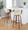 Curvo bar stool in Walnut Wood, Black Metal, Cream PU, featuring swivel and wood frame
