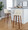Toriano 30" Mid-Century Modern Fixed-Height Barstool with Swivel in Walnut Wood and Cream Faux Leather with Round Chrome Metal Footrest- Set of 2 — lifestyle photo 2