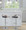 Cassis Mid-Century Modern Adjustable Barstool with Swivel in Chrome Metal, Light Grey Wood and Black Faux Leather with Oval Footrest — lifestyle photo 2