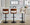 Cecina Contemporary Adjustable Barstool with Swivel in Black Metal, Walnut Wood, and Cream Faux Leather with Rounded T Footrest- Set of 2 — lifestyle photo 1