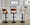 Cecina Contemporary Adjustable Barstool with Swivel in Black Metal, Walnut Wood, and Cream Faux Leather with Rounded T Footrest- Set of 2 — lifestyle photo 2