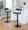 Demi Contemporary Adjustable Barstool with Swivel in Black Metal and Grey Faux Leather with Rounded T Footrest- Set of 2 — lifestyle photo 2