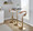 Grotto Contemporary Adjustable Barstool with Swivel in Gold Metal, Whitewashed Wood, and Oat Fabric with Rounded T Footrest — lifestyle photo 2