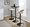 Grotto Contemporary Adjustable Barstool in Black Metal, Whitewashed Wood, and Oat Fabric with Rounded T Footrest — lifestyle photo 1