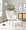 Izzy ottoman in Black Metal, White Sherpa, featuring tufted upholstery