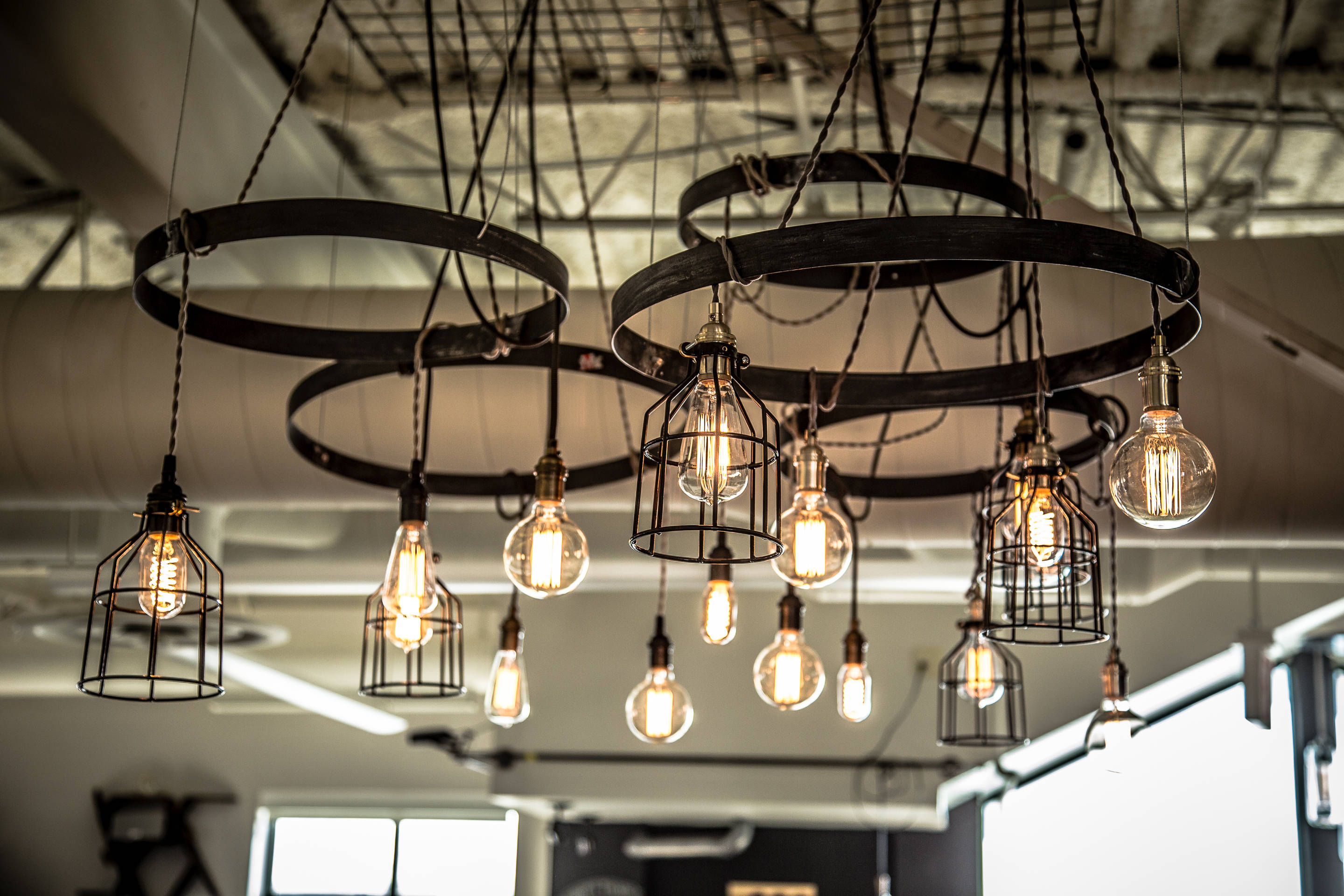 clypd-inc-office-space-in-somerville-ma-after-pic-16-pendants-hung-from-4-steel-hoops-mix-of-bulbs-and-cages-photos-by-nate-design-by-stephanie-6.jpg