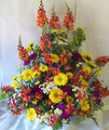 Fresh flowers in bold hues arranged in a wicker basket.