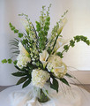 Elegant calla lilies, hydrangea and bells of Ireland in a stylized format.