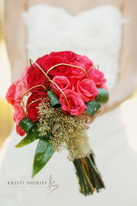 Hombre style bridal bouquet in a tight clutch with Coral roses and Deep coral carden roses with an accent of Gold seeded eucaliptis and Gold curly will to give it a textural quality. Wrapped in a gold Mesh ribbon. Perfect for the modern bride on her wedding day.
