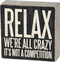 relax we're all crazy box sign 