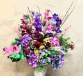 Artificial flower arrangement in a ceramic pot with purple flowers 