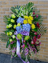 Medium size funeral standing spray with bright flowers 
