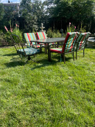 Glass top patio table and 4 stacked chairs with cushions and two swivel chairs