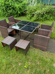 Compact faux wicker glass top patio table with seating for 8